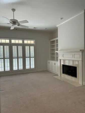 a view of an empty room with a fireplace and a window