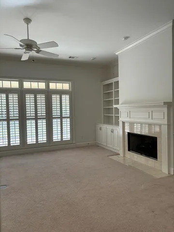 a view of an empty room with a fireplace and a window