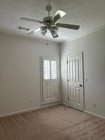 an empty room with windows and fan