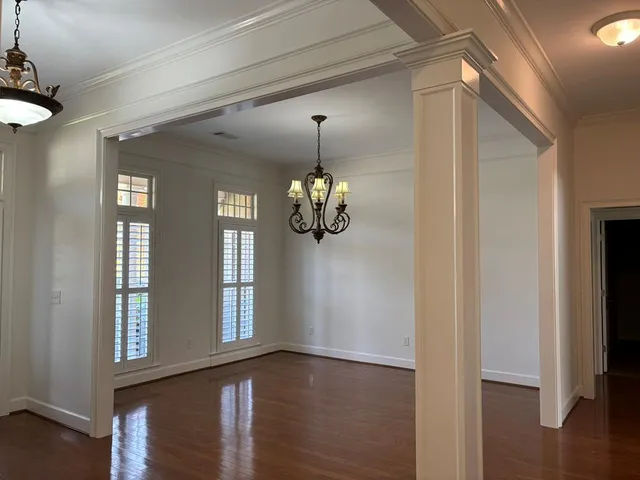 a view of a hallway with windows and chandelier