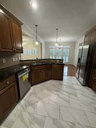 a large kitchen with granite countertop a sink counter space and cabinets