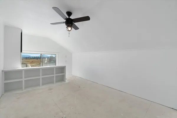 an empty room with closet and windows