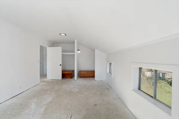 an empty room with windows and closet