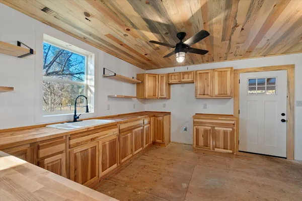 a kitchen with stainless steel appliances granite countertop a sink window and cabinets