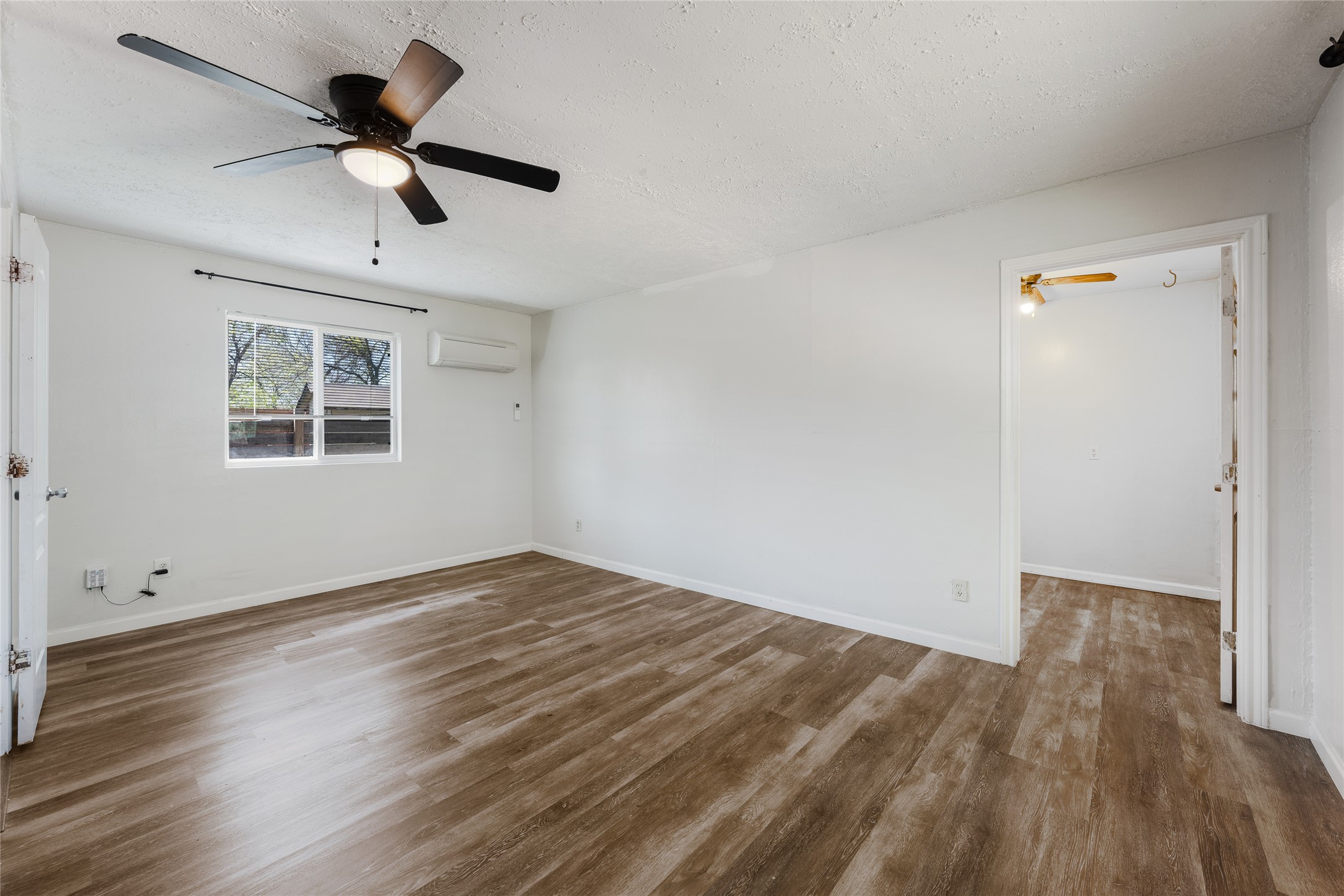 1116 Ebert Avenue, Unit B Austin, TX 78721 - Photo 16 of 28 an empty room with wooden floor ceiling fan and windows