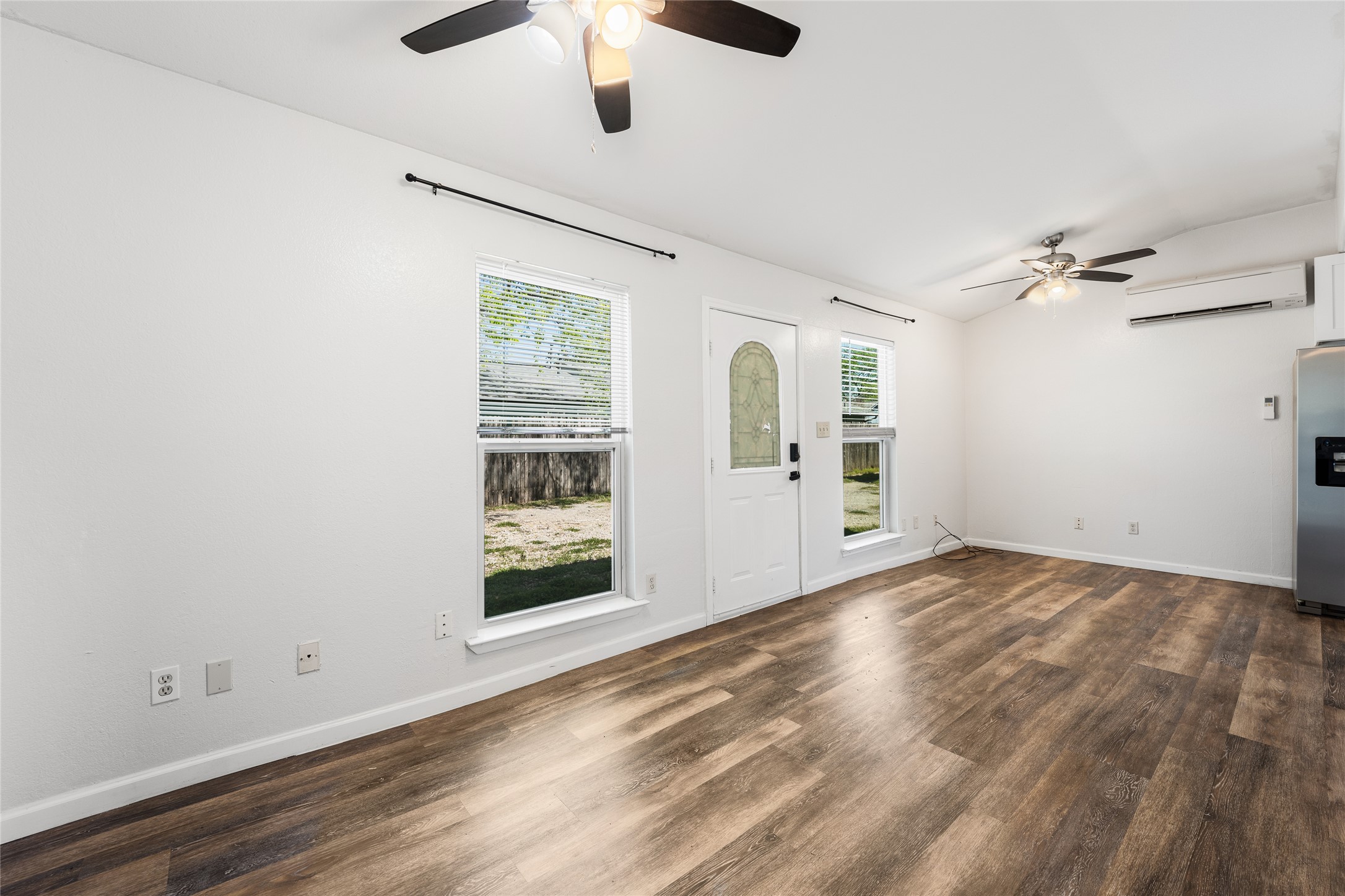 1116 Ebert Avenue, Unit B Austin, TX 78721 - Photo 10 of 28 an empty room with wooden floor chandelier fan and windows