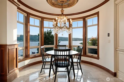 a dining room with furniture large windows and a chandelier
