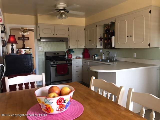 4317 South Travis Street Amarillo, TX 79110 - Photo 4 of 20 a kitchen with stainless steel appliances granite countertop a stove a sink and a microwave