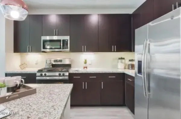 a kitchen with stainless steel appliances granite countertop a refrigerator and a stove top oven