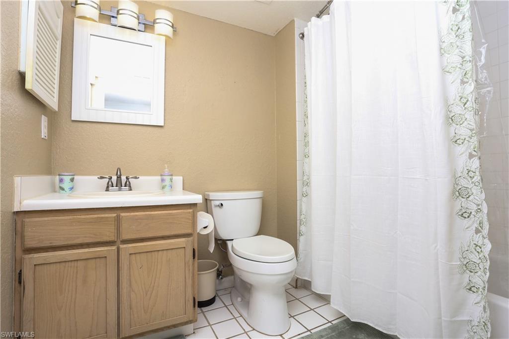 4650 St Croix Lane, Unit 731 Naples, FL 34109 - Photo 16 of 29 a bathroom with a sink a toilet and a mirror