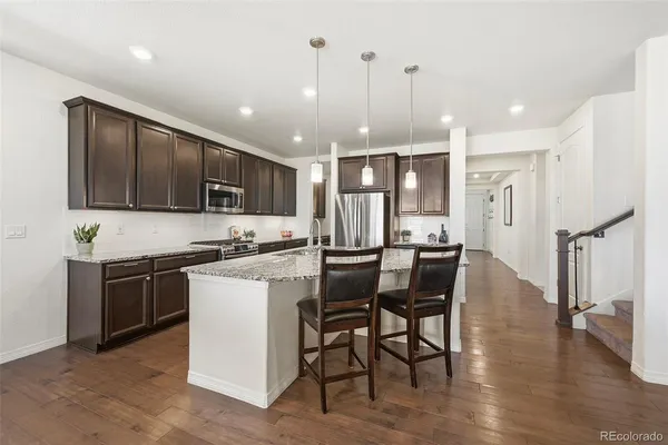 a kitchen with stainless steel appliances granite countertop a sink stove and refrigerator