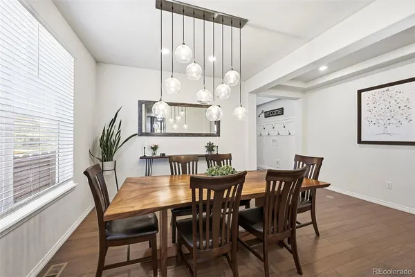 a kitchen with stainless steel appliances granite countertop a stove top oven a sink dishwasher and a refrigerator with wooden floor