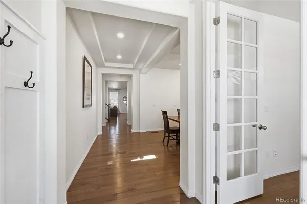 a kitchen with stainless steel appliances granite countertop a stove top oven a refrigerator a sink and a dining table with wooden floor