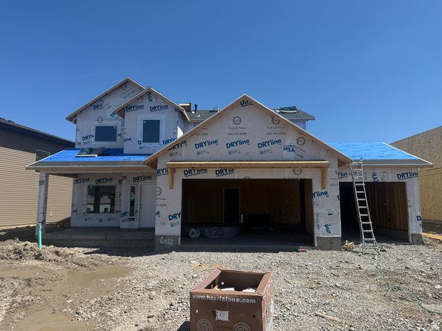Two-story construction featuring a prominent two-car garage with a third bay, a covered entry porch, and a gabled roofline