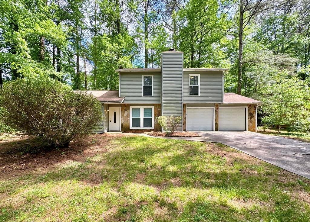 5298 Miller Road Southwest Lilburn, GA 30047 - Photo 1 of 1 a view of a yard in front of a house with large trees