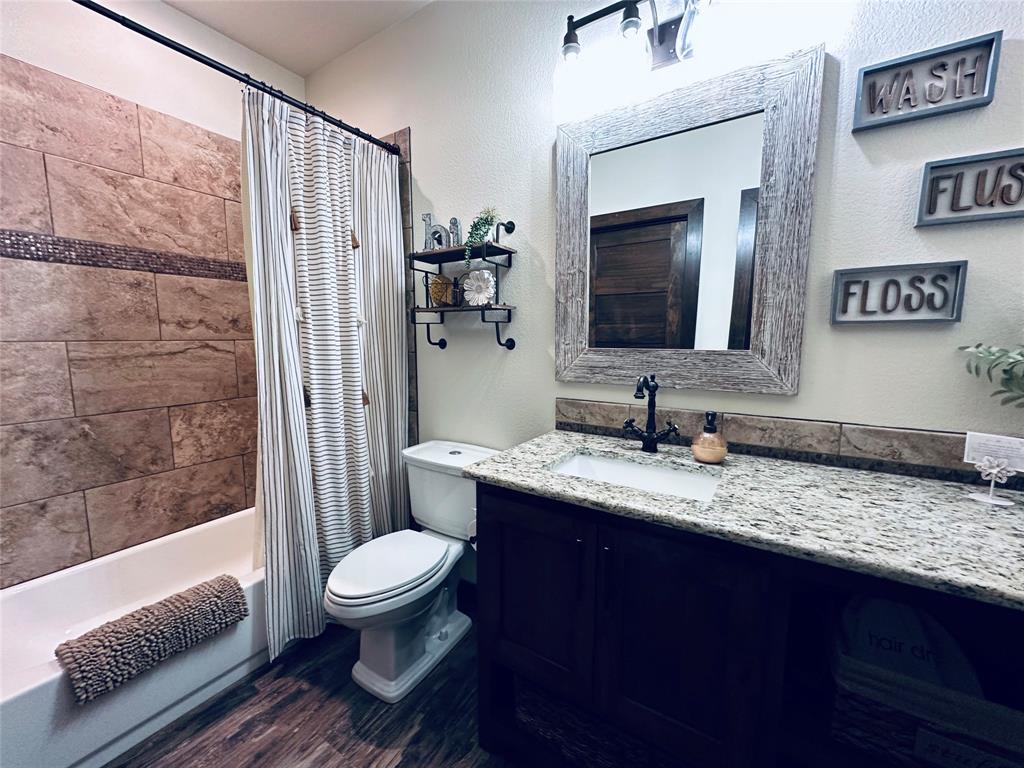 125 Drake Court Comanche, TX 76442 - Photo 11 of 35 a bathroom with a granite countertop sink toilet and shower
