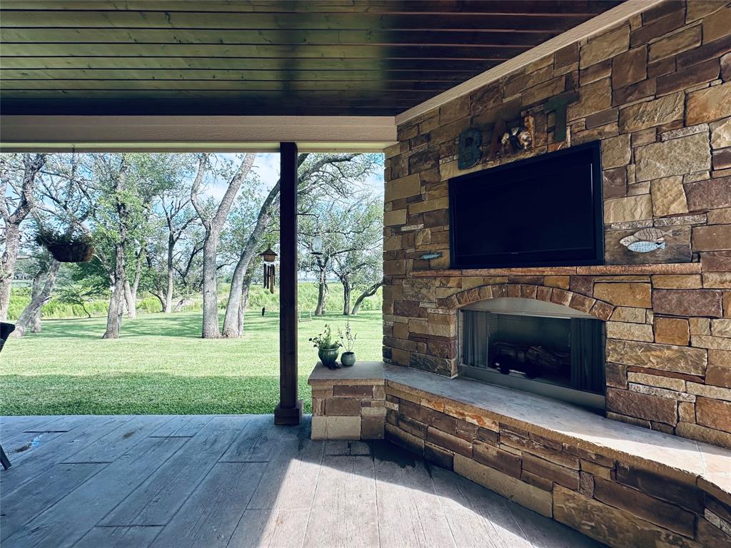 125 Drake Court Comanche, TX 76442 - Photo 14 of 35 a living room with a fireplace wooden floor and a large window
