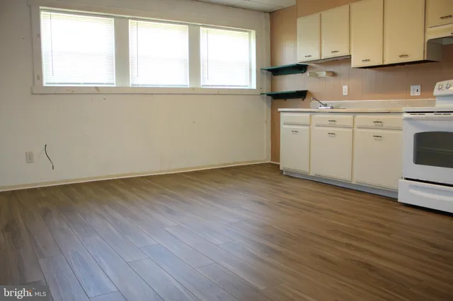 a kitchen with wooden floors and white cabinets