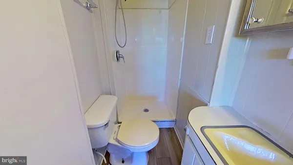 a bathroom with a granite countertop toilet a sink and a mirror