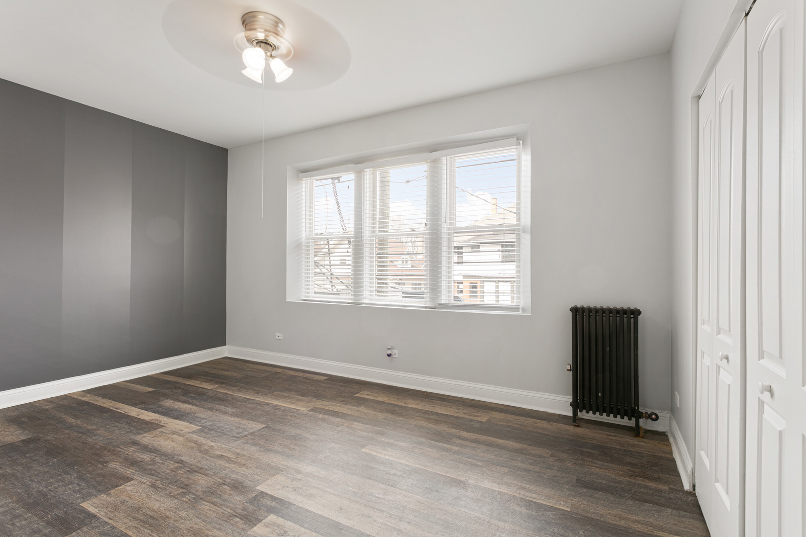 1608 West Sherwin Avenue, Unit 412 Chicago, IL 60626 - Photo 2 of 11 a view of an empty room with wooden floor and a window