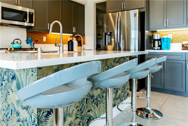 a kitchen with kitchen island a stove a chimney a sink and a dining table view