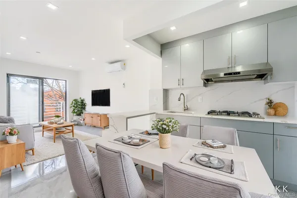 a kitchen with a stove a refrigerator and a dining table with wooden floor