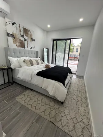 a bedroom with a bed lamp and a large window