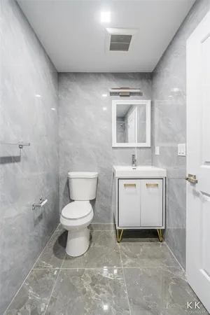 a bathroom with a toilet sink and mirror