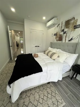 a bedroom with a bed lamp and a mirror