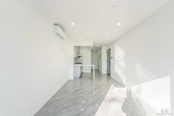 a view of a hallway with wooden floor and a living room