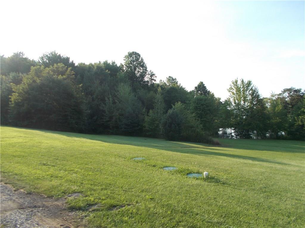124 Currie Road Slippery Rock, PA 16057 - Photo 23 of 25 Side yard. Notice the pond behind the trees. Although not part of the property, it adds a visual benefit...without the maintenance.