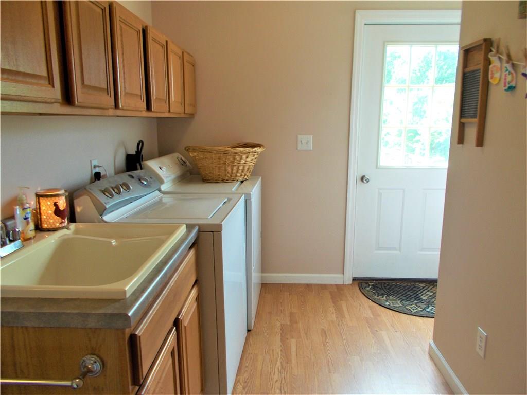124 Currie Road Slippery Rock, PA 16057 - Photo 9 of 25 Laundry room. Main level. 6x12. Features lots of cabinet space and utility sink with vanity. The G.E. Profile washer and Maytag dryer are included. The door leads to the rear deck.