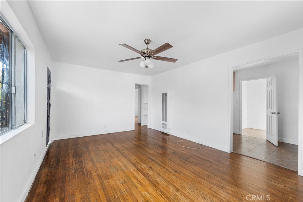 10004 San Fernando Road Pacoima, CA 91331 - Photo 2 of 12 an empty room with wooden floor and a ceiling fan