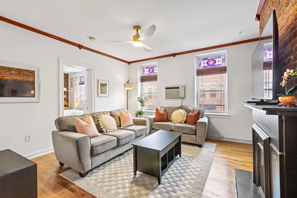 a living room with furniture a flat screen tv and a window