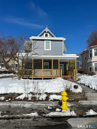 a front view of a house with yard and trees in the background