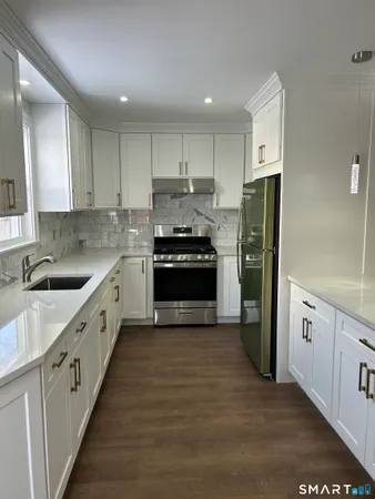 a large kitchen with a stove top oven a refrigerator a sink and dishwasher
