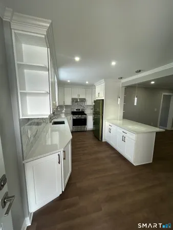 a kitchen with stainless steel appliances kitchen island granite countertop a stove a sink and a refrigerator