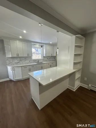 a large kitchen with stainless steel appliances a large counter top and a stove