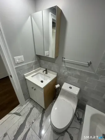 a bathroom with a toilet sink and mirror