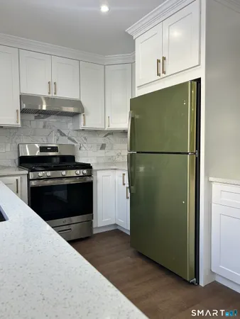 a kitchen with a refrigerator stove and white cabinets