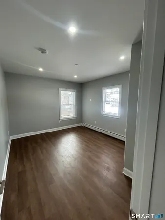 a view of an empty room with wooden floor