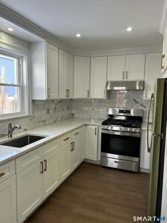 a kitchen with sink a microwave and cabinets