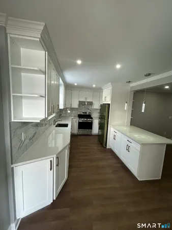 a large kitchen with stainless steel appliances lot of white cabinets