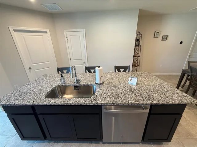 a kitchen with kitchen island granite countertop a sink and granite counter tops
