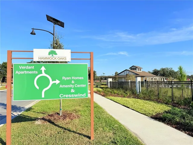 a view of swimming pool with outdoor seating and trees in the background