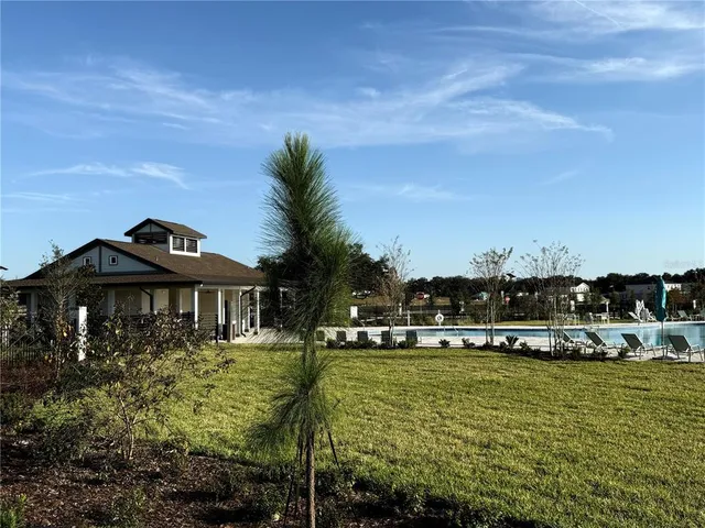 a front view of house with yard and trees in the background
