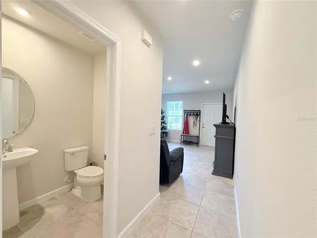 a view of a hallway with toilet and a sink