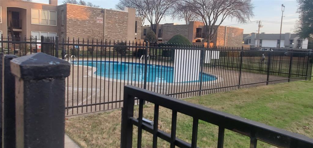 5532 Boca Raton Boulevard, Unit 290 Fort Worth, TX 76112 - Photo 2 of 16 Fenced in-ground swimming pool with surrounding concrete decking, featuring a black wrought iron fence