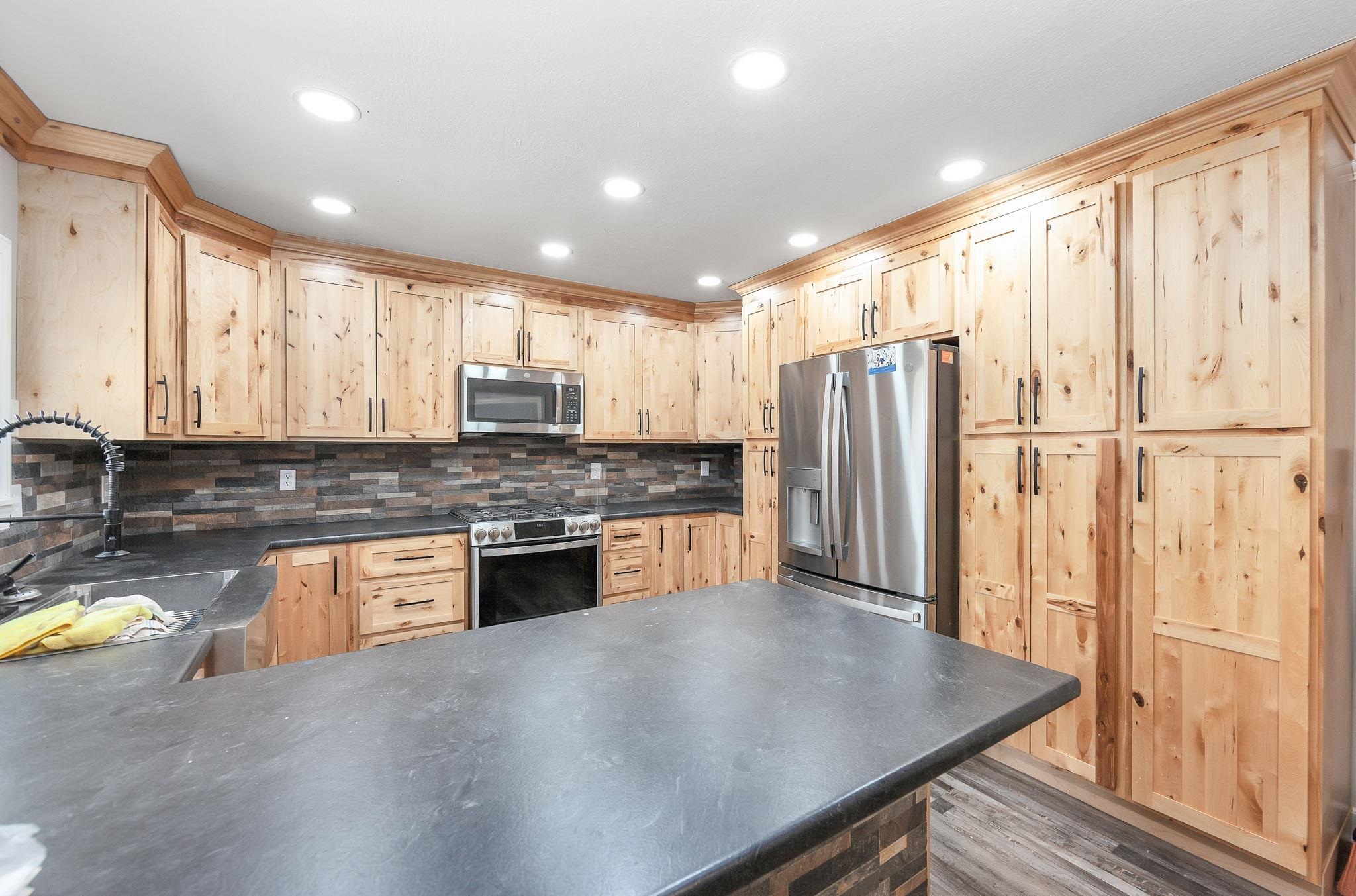 2656 Curve Woodville Road Ripley, TN 38063 - Photo 31 of 39 a kitchen with stainless steel appliances granite countertop a refrigerator a sink dishwasher a stove and white countertops with wooden floor