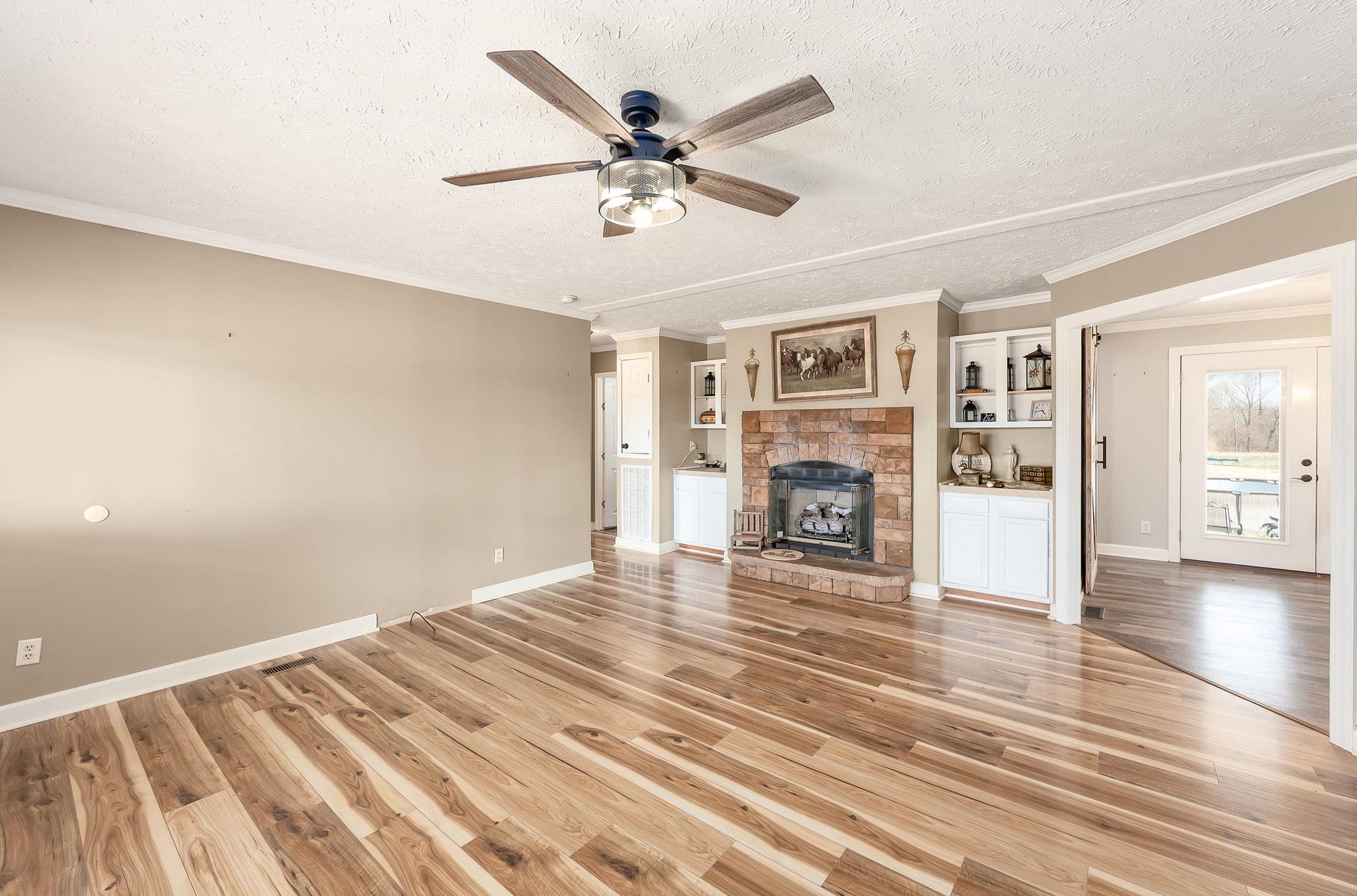 2656 Curve Woodville Road Ripley, TN 38063 - Photo 4 of 39 a view of livingroom with a flat screen tv with wooden floor and a ceiling fan